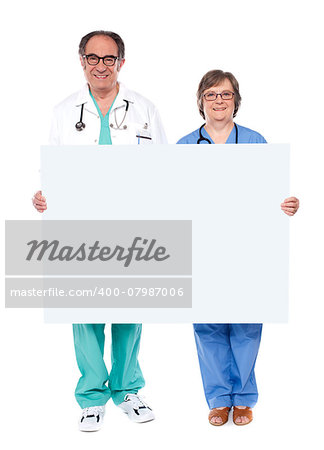 Experienced medical professionals showing blank billboard. Full length portrait