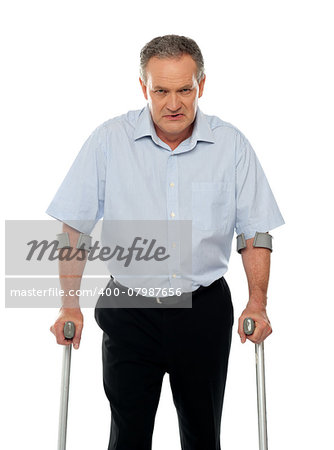 Angry aged man with crutches looking at you. All on white background