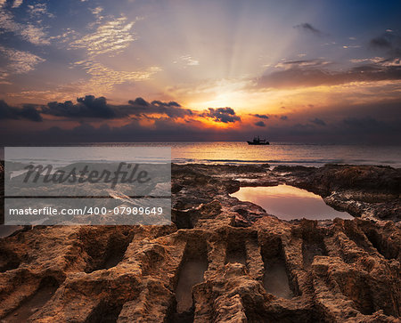 Sunset over the Sea with Rocks and Rock Pool in Foreground