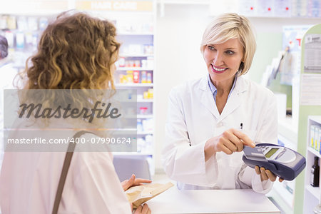 Pharmacist using card machine at pharmacy