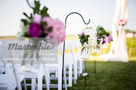 Flowers Hanging at End of Rows of Chairs at Wedding