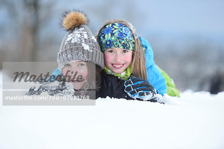 Close-up portrait of two girls playing in the snow, winter, Bavaria, Germany