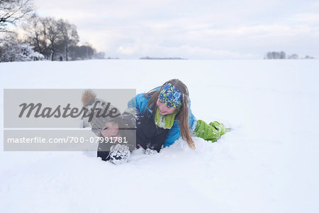 Two girls playing in the snow, winter, Bavaria, Germany