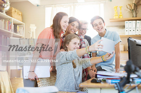 Group of teenagers taking selfie with digital tablet
