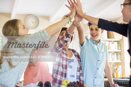Group of teenagers doing high five in living room