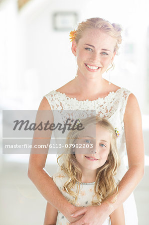 Portrait of bride and bridesmaid in domestic room