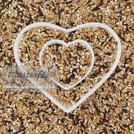 Healthy seven grain and cereal food mixture in heart shaped bowls and forming an abstract background.