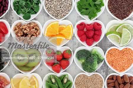 Super food selection for health diet in porcelain bowls over distressed wooden background.