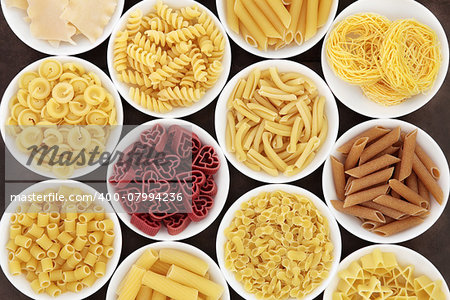 Italian dried pasta  shapes in white porcelain bowls.