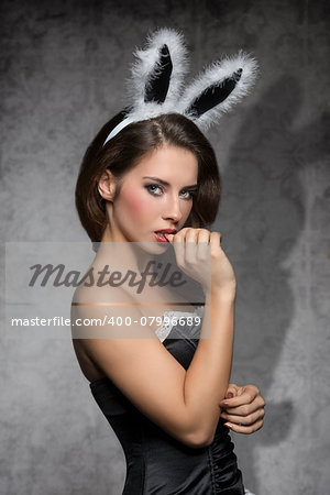 Beautiful, charming, sexy, elegant brunette woman in black corset and fluffy rabbit, easter, ears with nice make up.