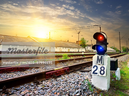 Railway semaphore near industrial station at sunset