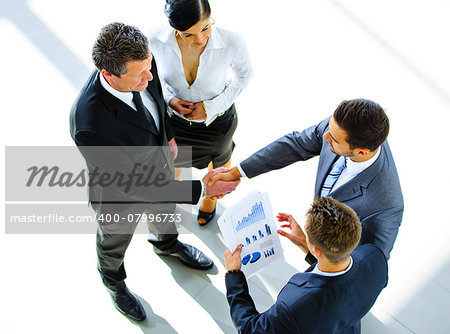 Top view of a two businessman shaking hands - Welcome to business