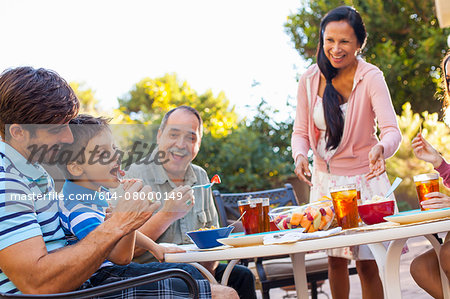 Three generation family dining in garden