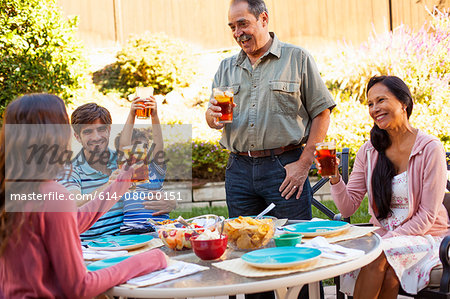 Three generation family dining in garden
