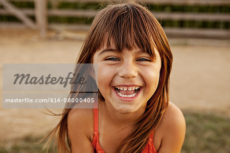 Portrait of laughing girl in farmyard