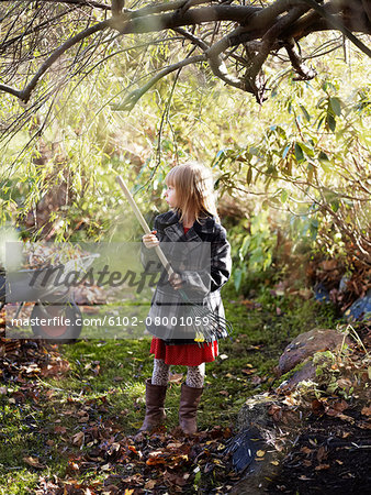 Girl in garden holding rake