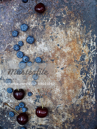 Blueberries and cherries on rusty background