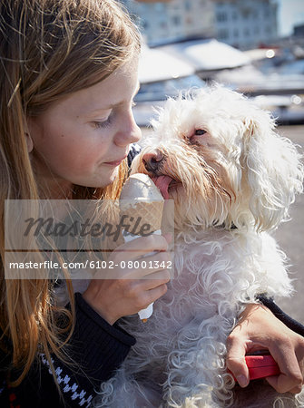 Girl and dog eating ice-cream together