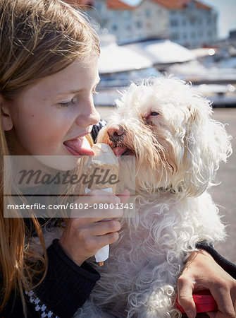 Girl and dog eating ice-cream together
