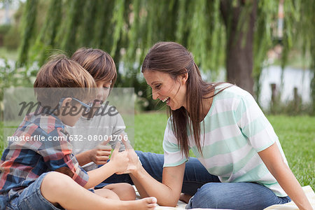 Mother teaching her sons how to thumb wrestle