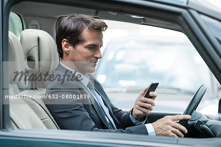 Man looking at cell phone while driving Man looking at cell phone while driving