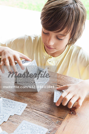 Boy building house of cards