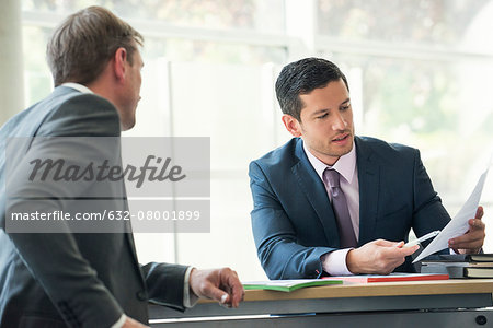 Businessmen discussing contract in meeting Businessmen discussing contract in meeting