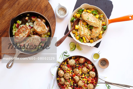 Three healthy skillet dinners with pork, meatballs and chicken, studio shot on white background