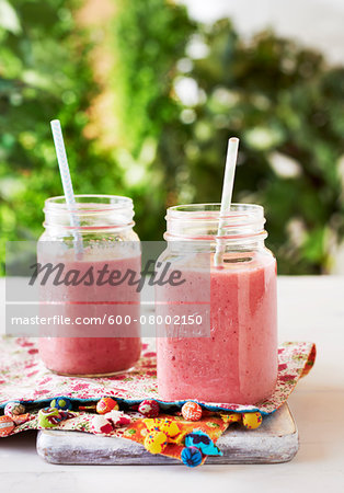 Berry Smoothies in mason jars with straws, outdoor studio shot