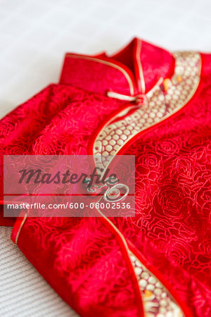 Close-up of a red, cheongsam dress, studio shot on white background