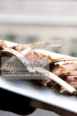 Close-up of lamb chops with bones on a platter, at an event, Canada