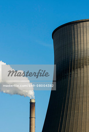 Top of smoke stack and cooling tower with blue sky