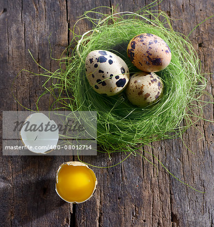 quail eggs in a nest on a wooden background