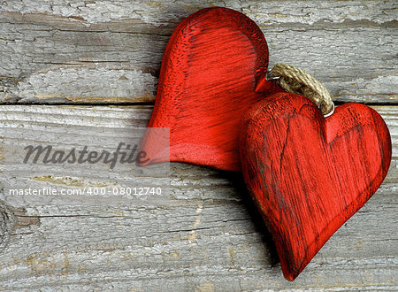 Pair of Handmade Wooden Red Hearts isolated on Rustic Wooden background. Top View