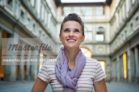 Happy young woman near uffizi gallery in florence, italy