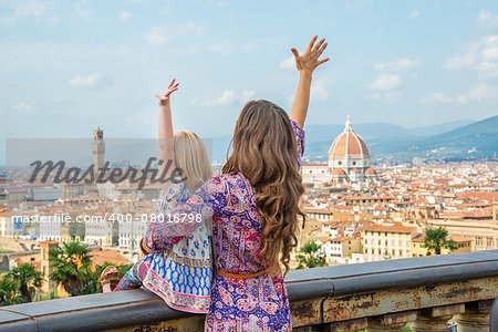 Mother and baby girl looking on panoramic view of florence, italy and rejoicing