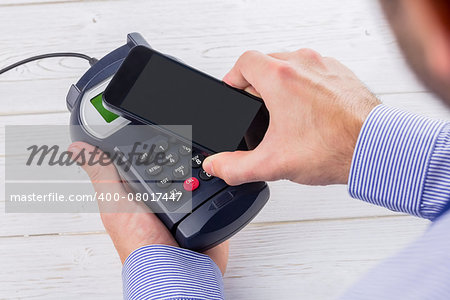 Man using smartphone to express pay on a wooden table