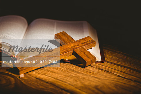 Open bible with crucifix icon on wooden table