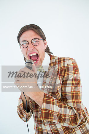 Happy geeky hipster singing with microphone on white background