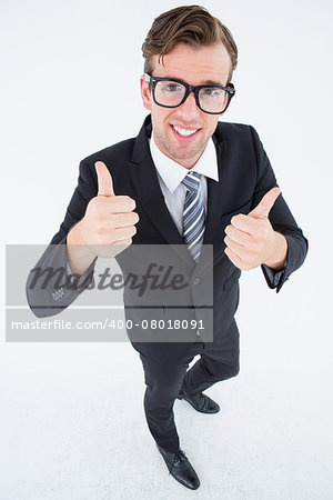 Geeky hipster smiling at camera with thumbs up on white background