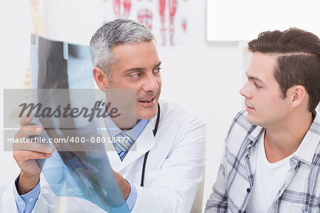 Doctor showing X rays to his patient in medical office