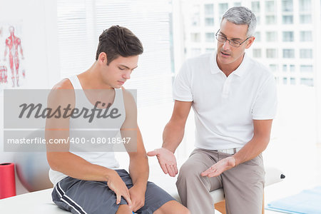 Doctor explaining something to his patient in medical office