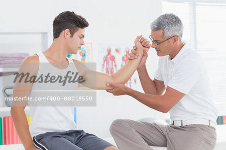 Doctor examining his patient arm in medical office
