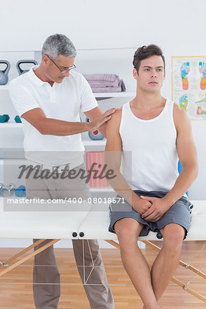 Doctor examining his patient shoulder in medical office