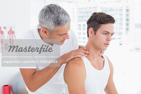 Doctor examining his patient neck in medical office