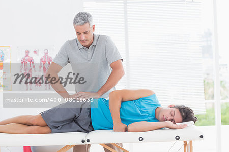 Doctor examining his patient pelvis in medical office