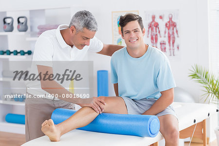Doctor examining his patient leg in medical office