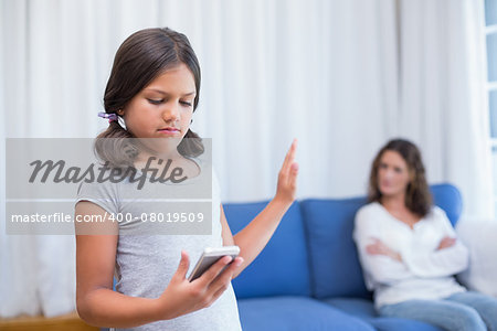 Naughty girl using smartphone in the living room