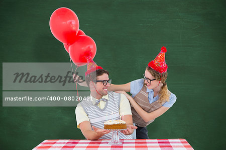 Geeky hipster couple celebrating his birthday  against green chalkboard