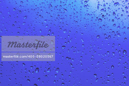 Blue drops of rain on a window glass